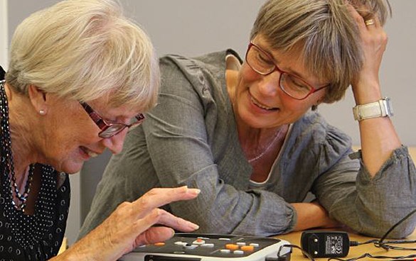 Två kvinnor använder talboksspelare.
