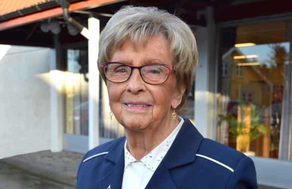 Ulla Borgius står framför en entré. Hon bär en blå kavaj.