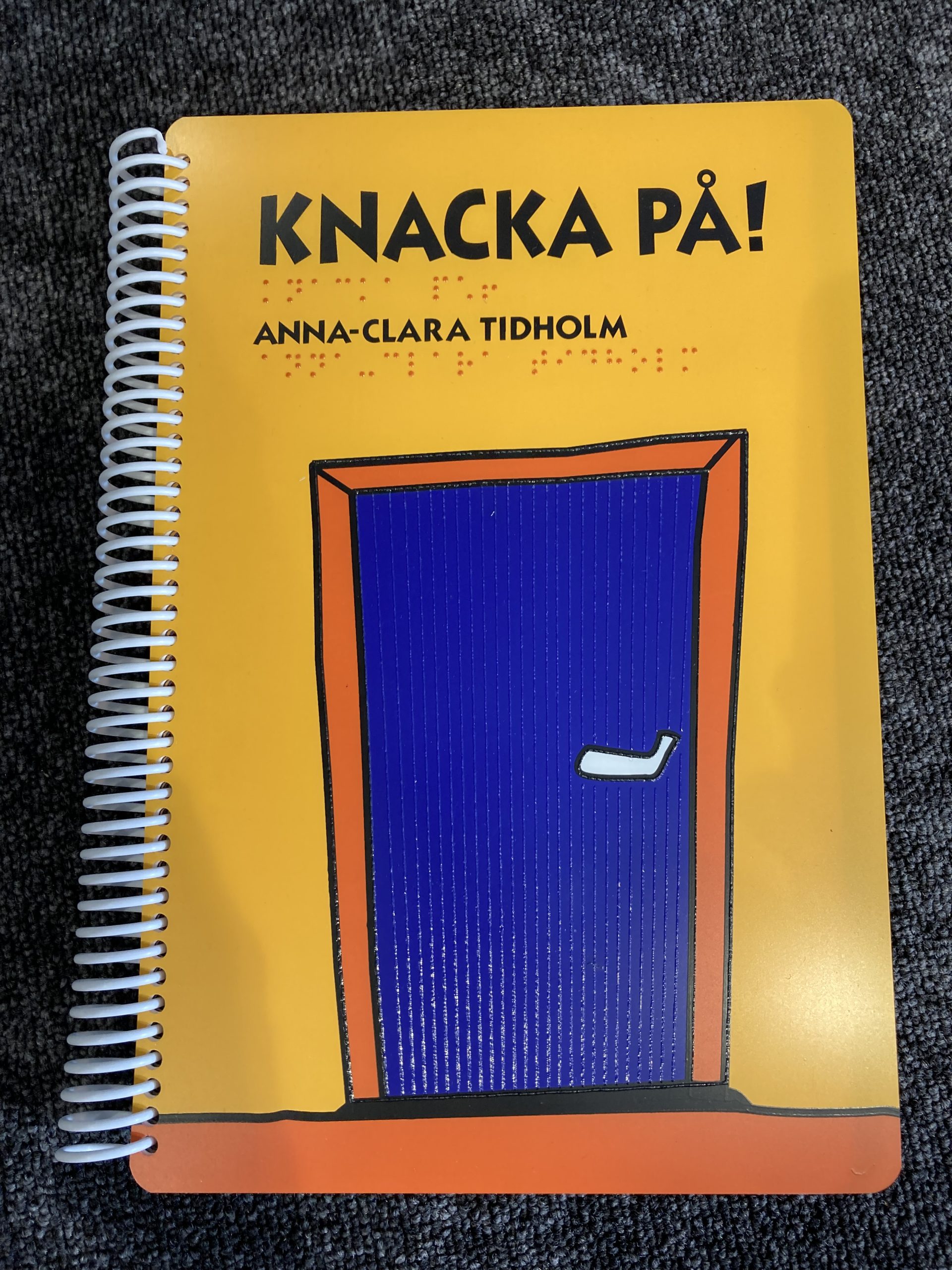 Omslaget till boken Knacka på- En blå dörr mot en gul bakgrund.