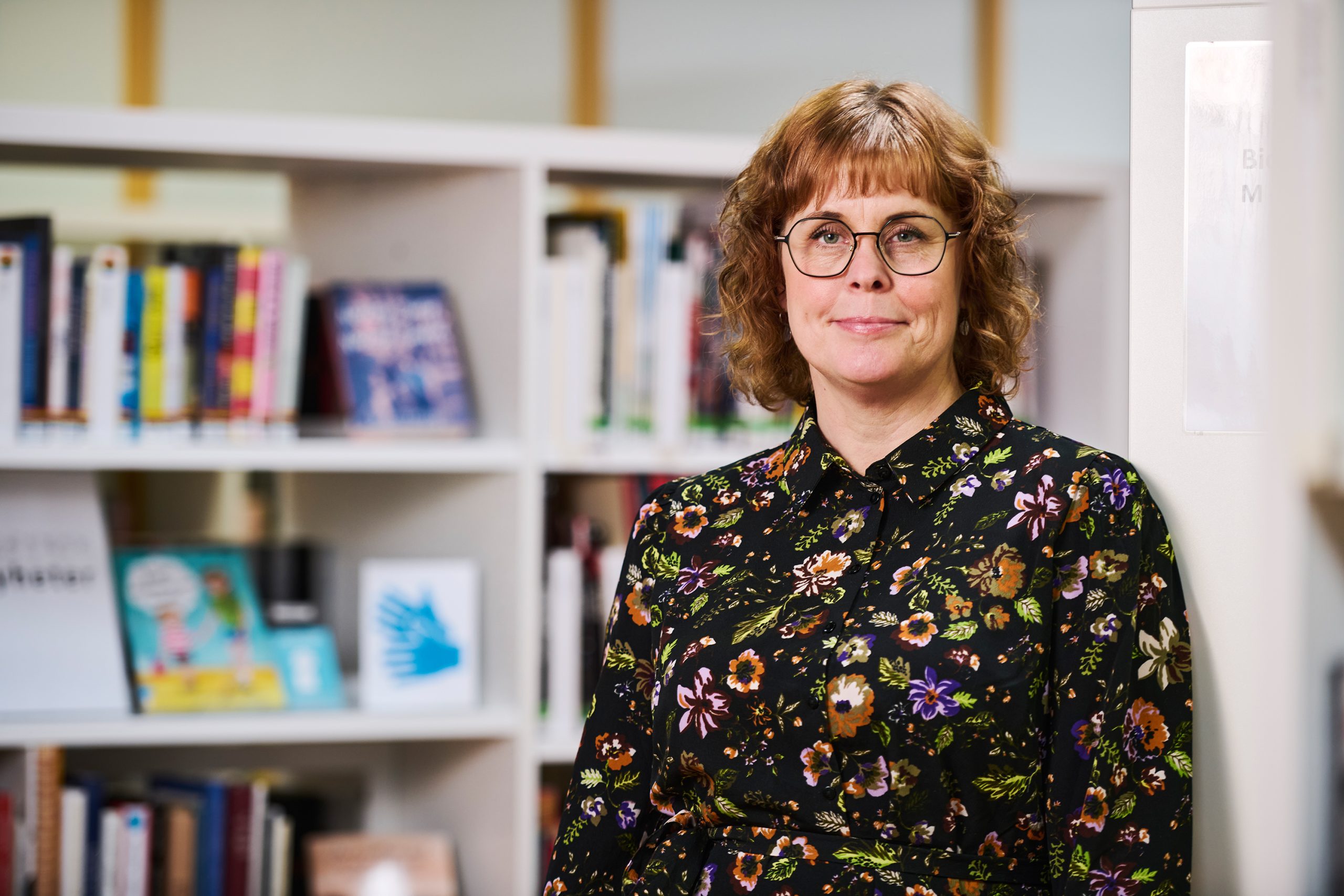 Desirée Stensdotter vid bokhyllorna på Piteå Stadsbibliotek.