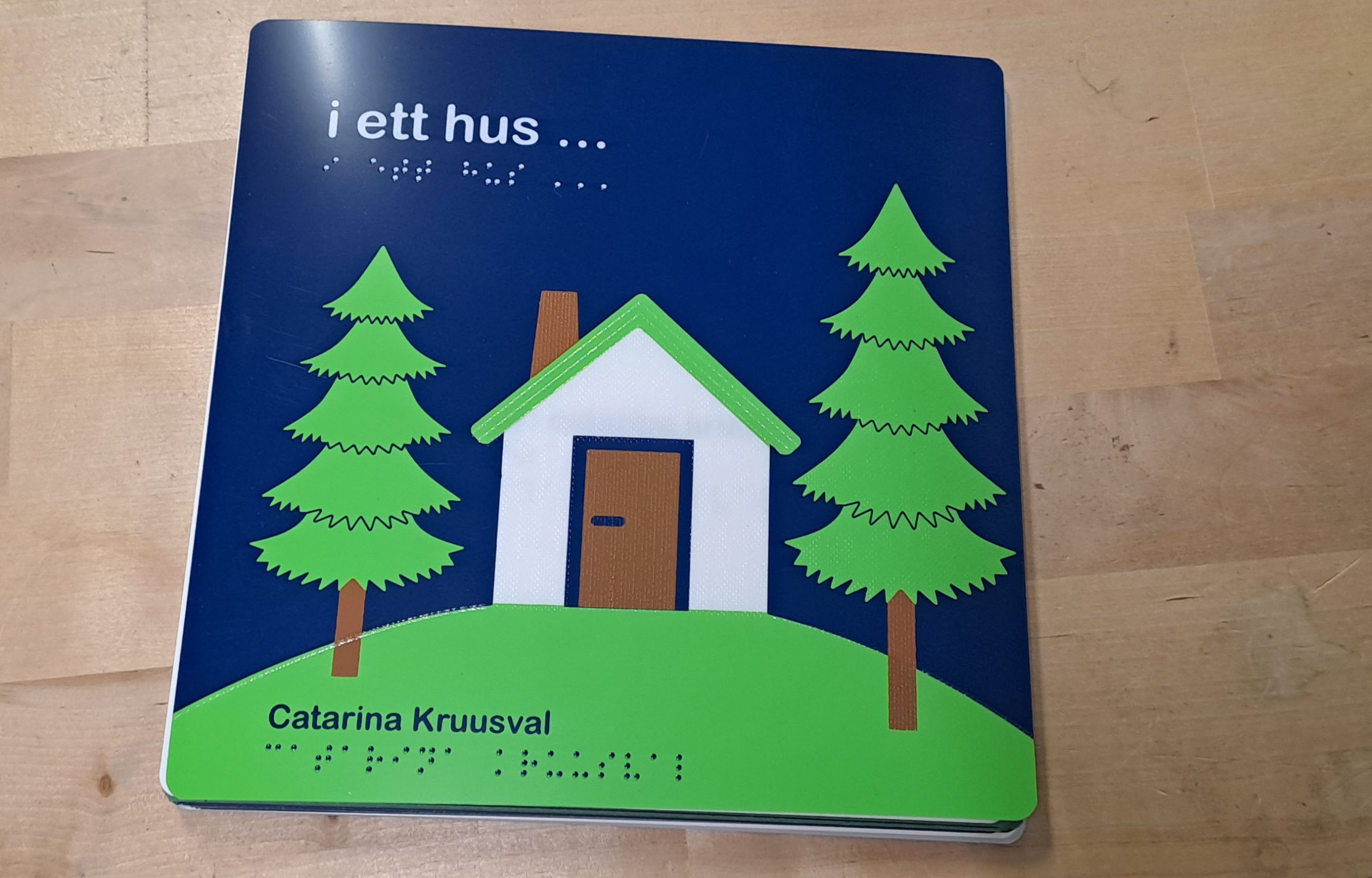 En vit liten stuga omgiven av två gröna granar.