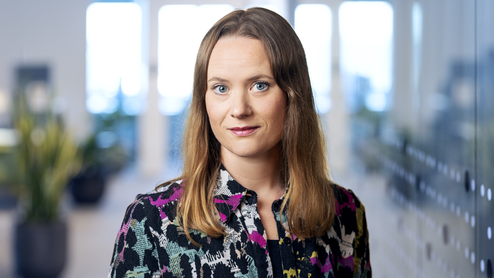 En porträttbild på Malin Lundqvist i ett kontorslandskap.