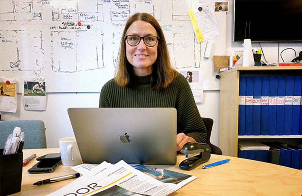Bilden visar 8 Sidors chefredaktör Marie Hillblom på sitt kontor framförsin bärbara dator. Hon har axellångt brunt hår och glasögon.