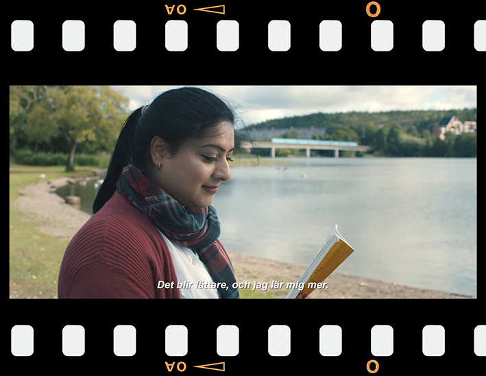 Bild från filmen, där Fozia sitter vid en sjö och läser en bok. Bilden ramas in av en filmremsa.