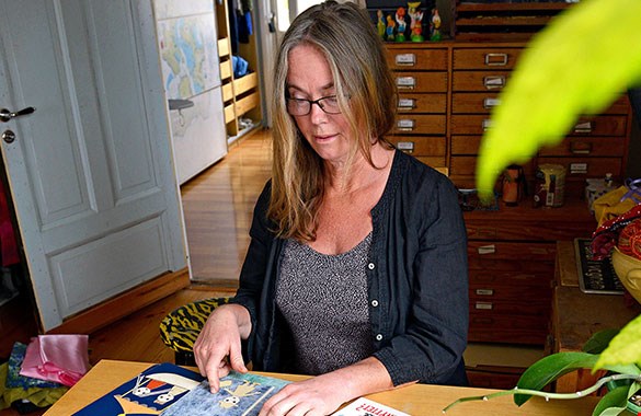 Bilden visar Maria Beskow vid sitt skrivbord när hon tillverkar en bok.