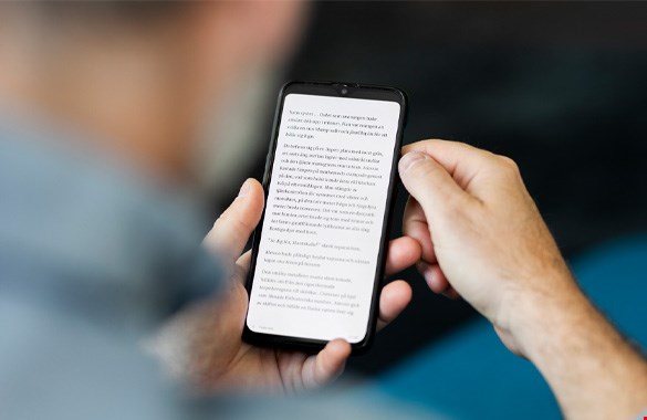 En person läser en e-bok i en mobiltelefon.