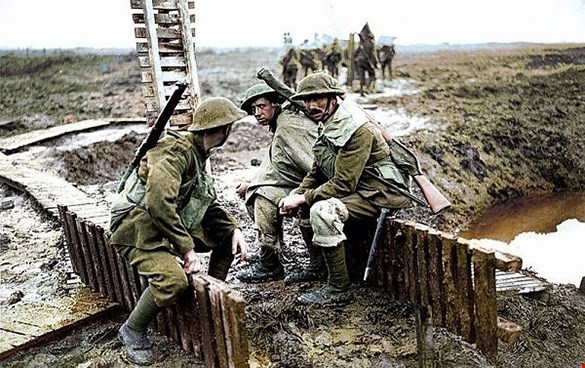 Trötta soldater sitter bredvid en skyttegrav
