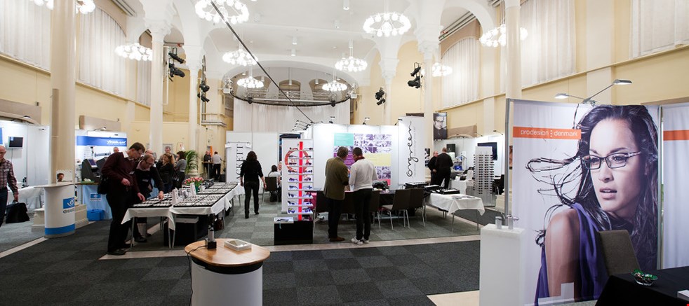 Picture showing the pillar hall exhibitor area, with several people and booths 