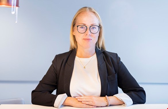 Elna Jönsson sitter vid ett skrivbord på ett kontor.