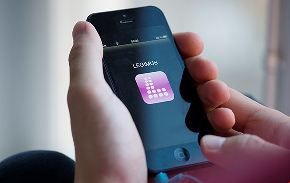 Detaljbild på smart mobiltelefon med logotypen för appen Legimus på skärmen.