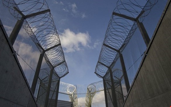 Bild på murar runt ett fängelse med taggtråd